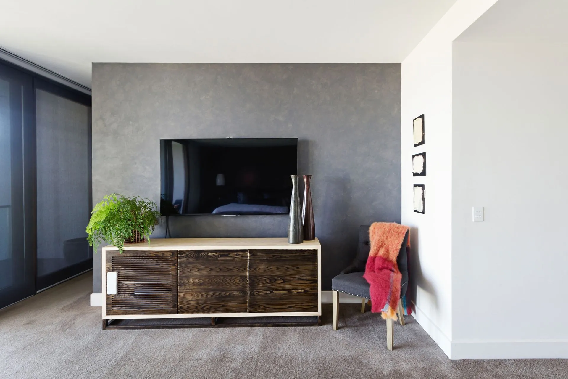 A living room with a large flat screen tv on the wall.