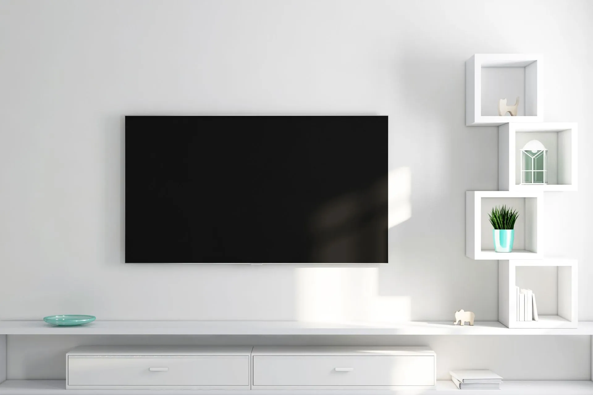 A flat screen tv is mounted on a white wall above a white entertainment center.